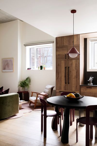 The ground-floor windows flood the apartment with natural light. For the dining area, Lin commissioned a table by Moving Mountains and installed a pendant light by In Common With.