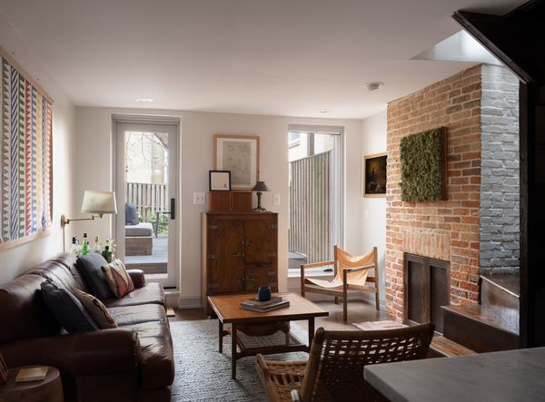 The first-level living area has white oak floors and a nonworking fireplace with a brick surround.