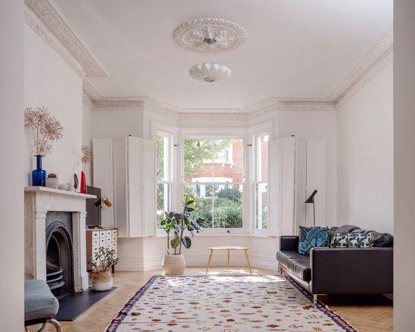 Alex and Jean filled the living area with furniture from their previous homes. New double-glazed timber-sash windows and custom shutters—a £38,000 splurge—flood the space with light.