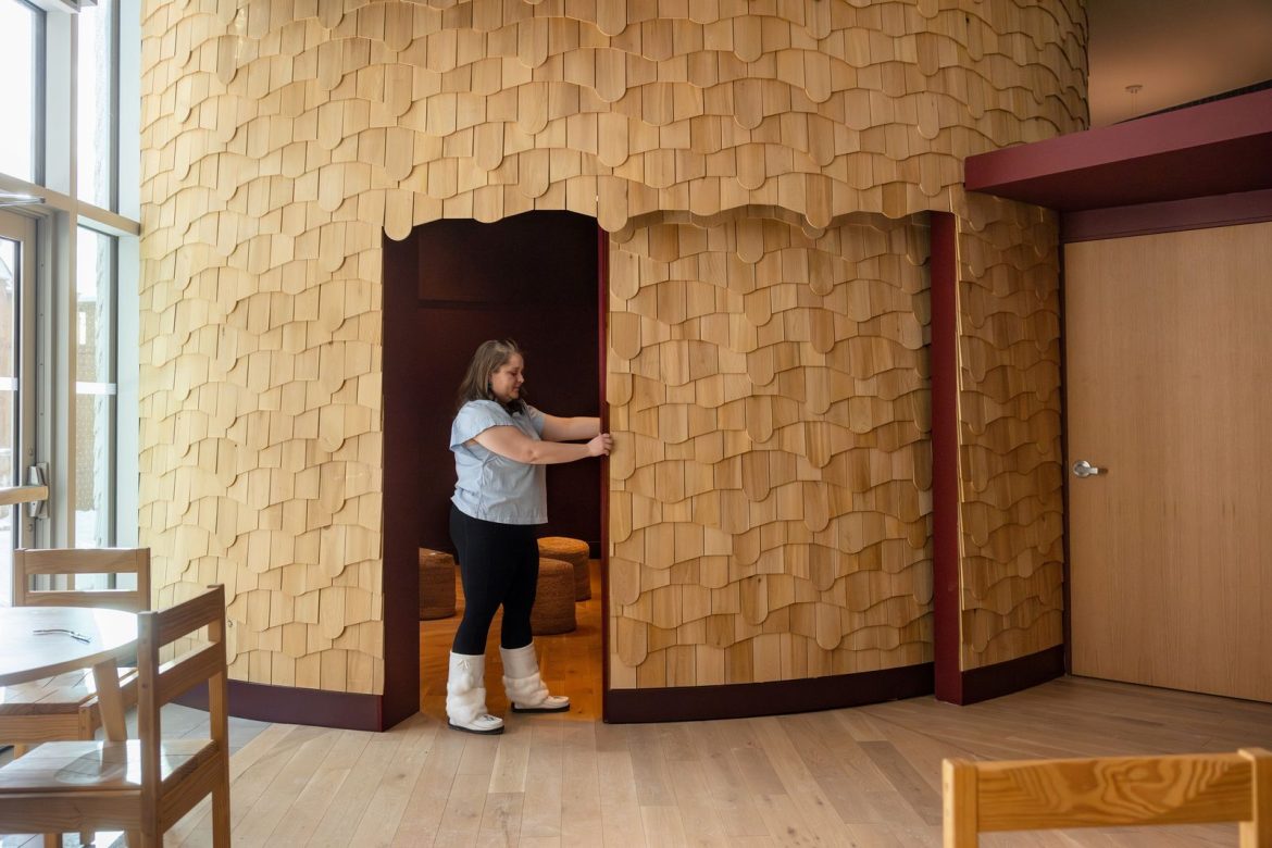 belyea-opens-the-sliding-door-to-the-nookomis-which-is-clad-in-cedar-planks-cut-in-an-irregular-wave-pattern.jpg