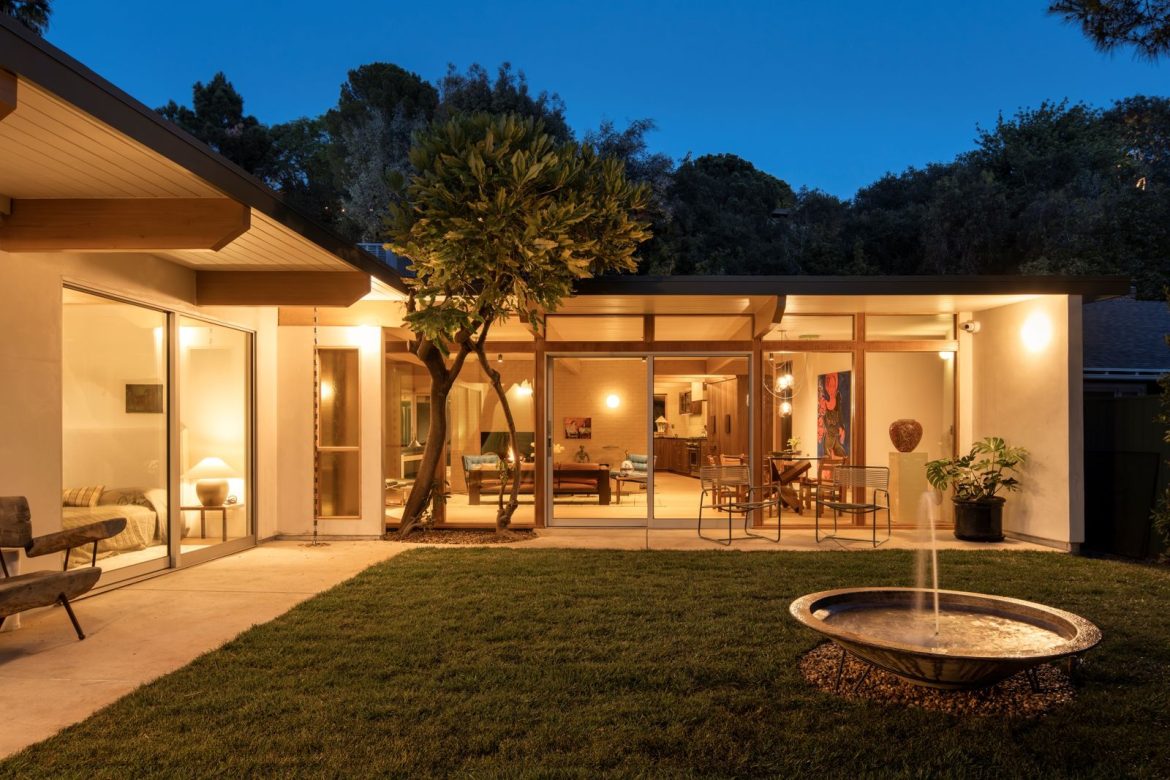 local-firm-ome-dezin-saved-this-midcentury-homes-post-and-beam-ceilings-and-brick-fireplace-while-bringing-in-ribbed-grass-a-circular-skylight-and-a-built-in-kitchen-banquette.jpg