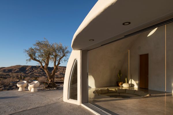 The primary material is concrete, creating an otherworldly, monolithic dome amidst the desert landscape.