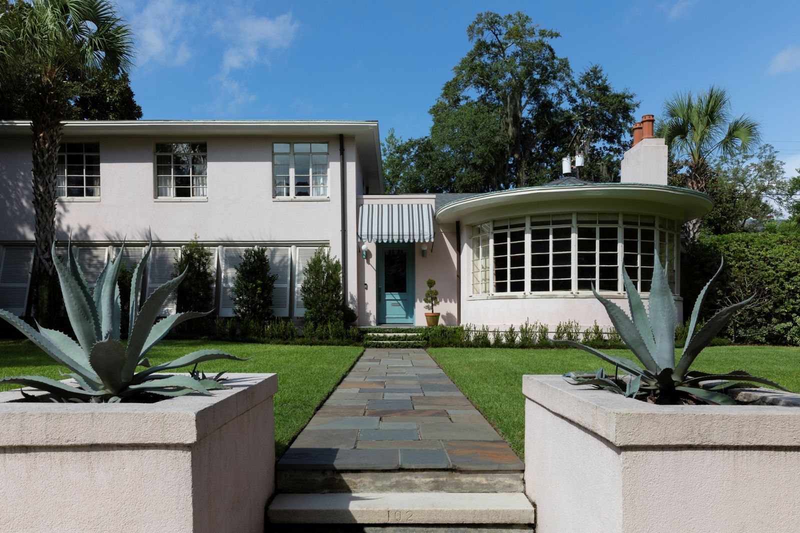 This International Style home in Georgia is packed to the brim with colorful walls, cottagecore curtains, kitschy lighting, and pink porcelain bath fixtures.